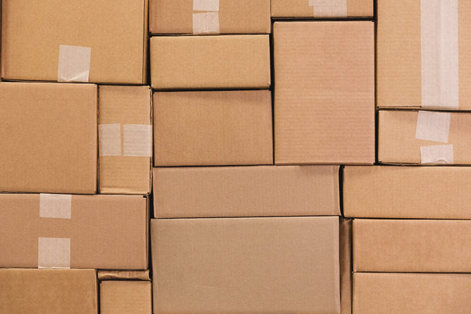 Stack of brown cardboard boxes with tape, indicating packaging or shipping.