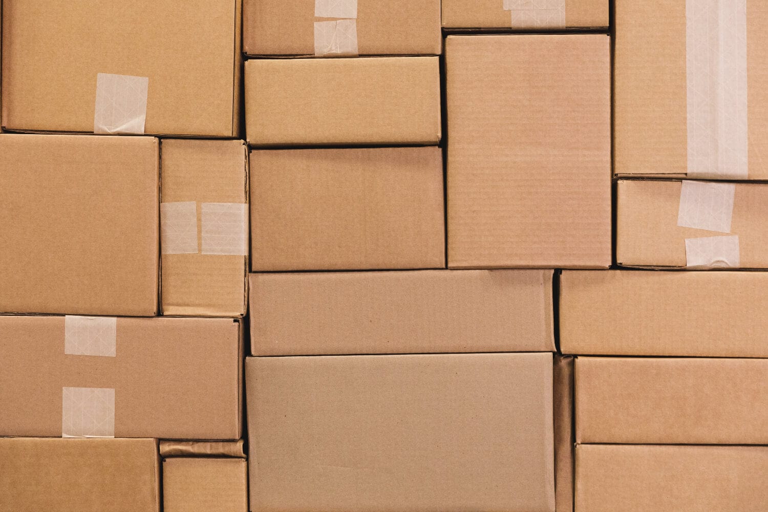 Stack of brown cardboard boxes with tape, indicating packaging or shipping.