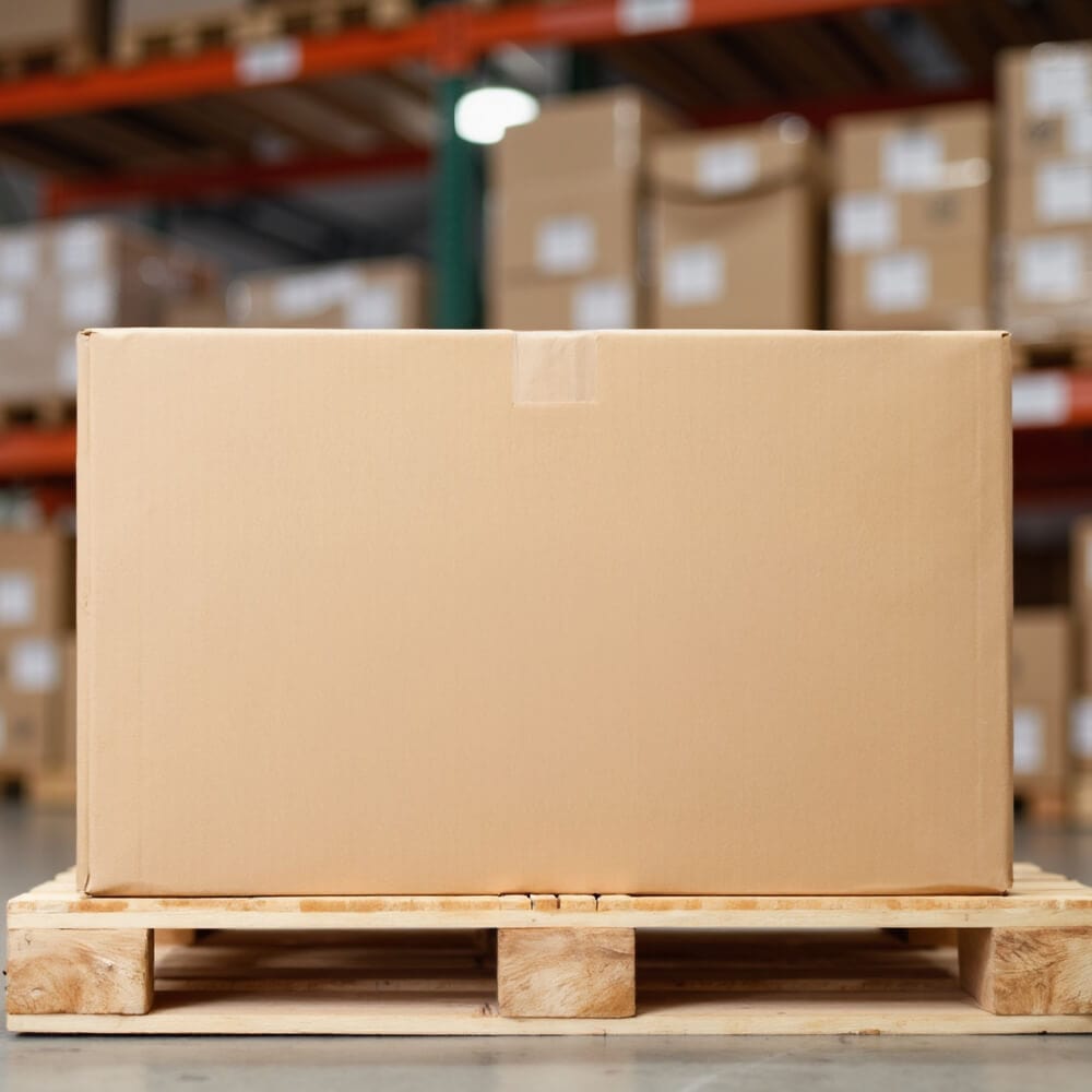 Cardboard box on a wooden pallet in a warehouse setting