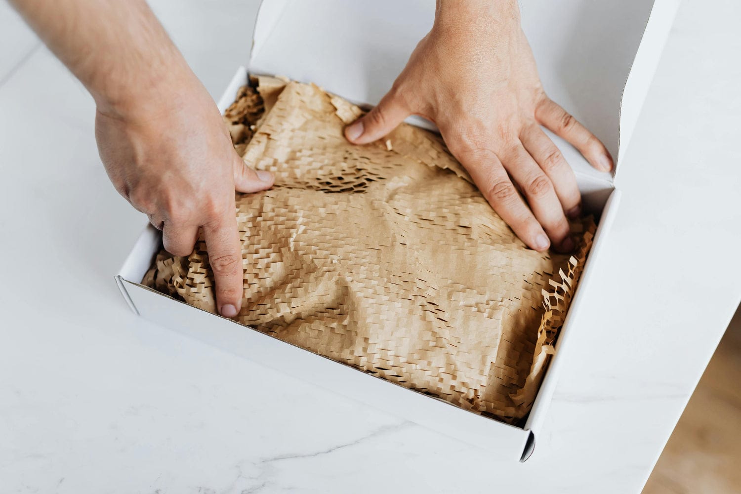 Photograph of packing a white box with hex paper